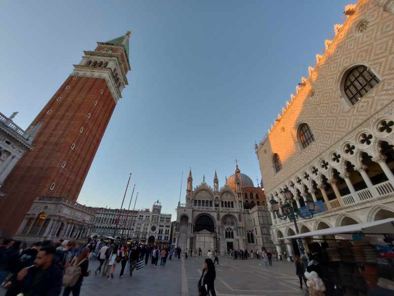 A bright lit tent in the forest with the night sky and stars above